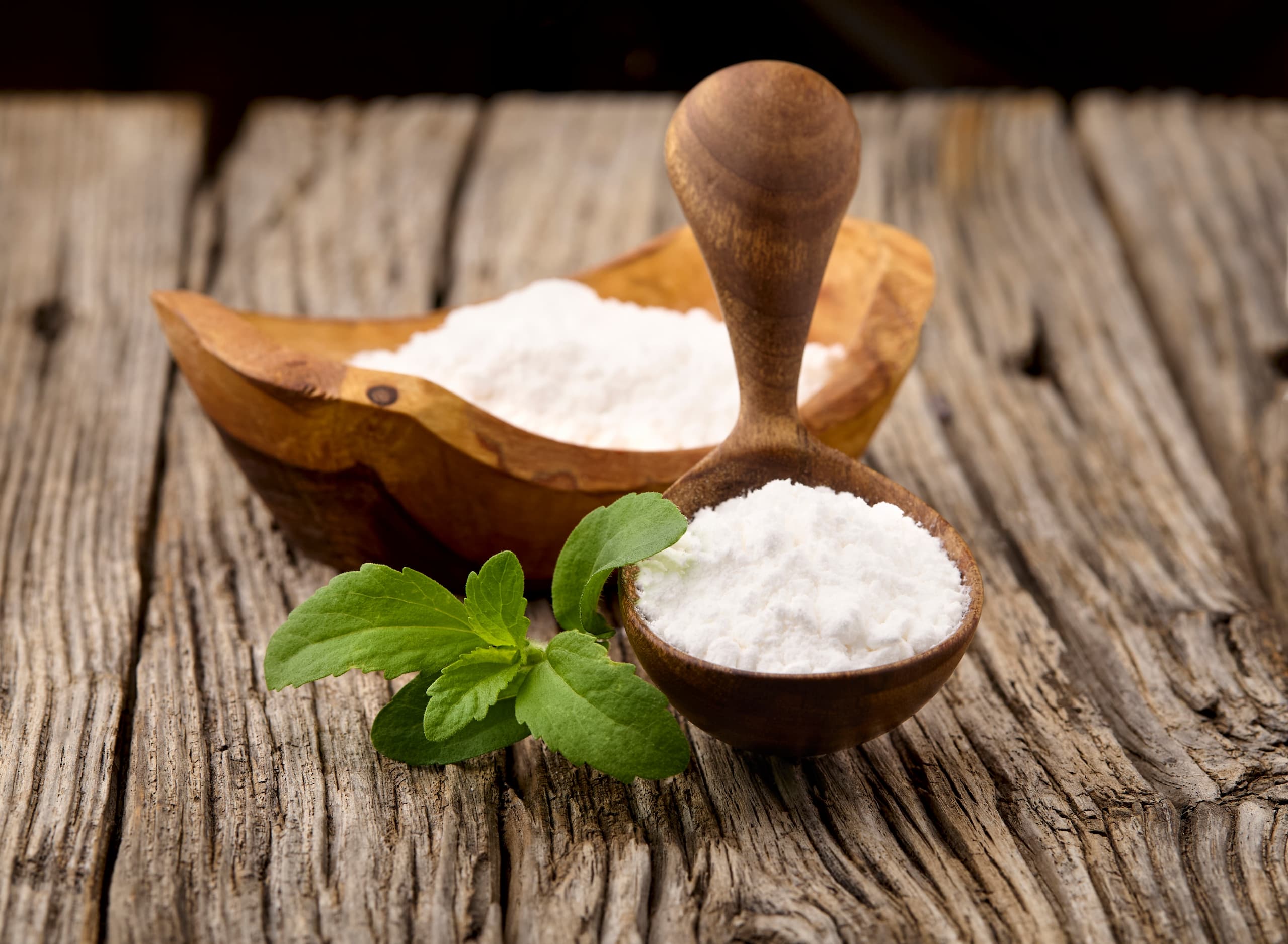 Stevia in a wooden bowl with a wooden spoon