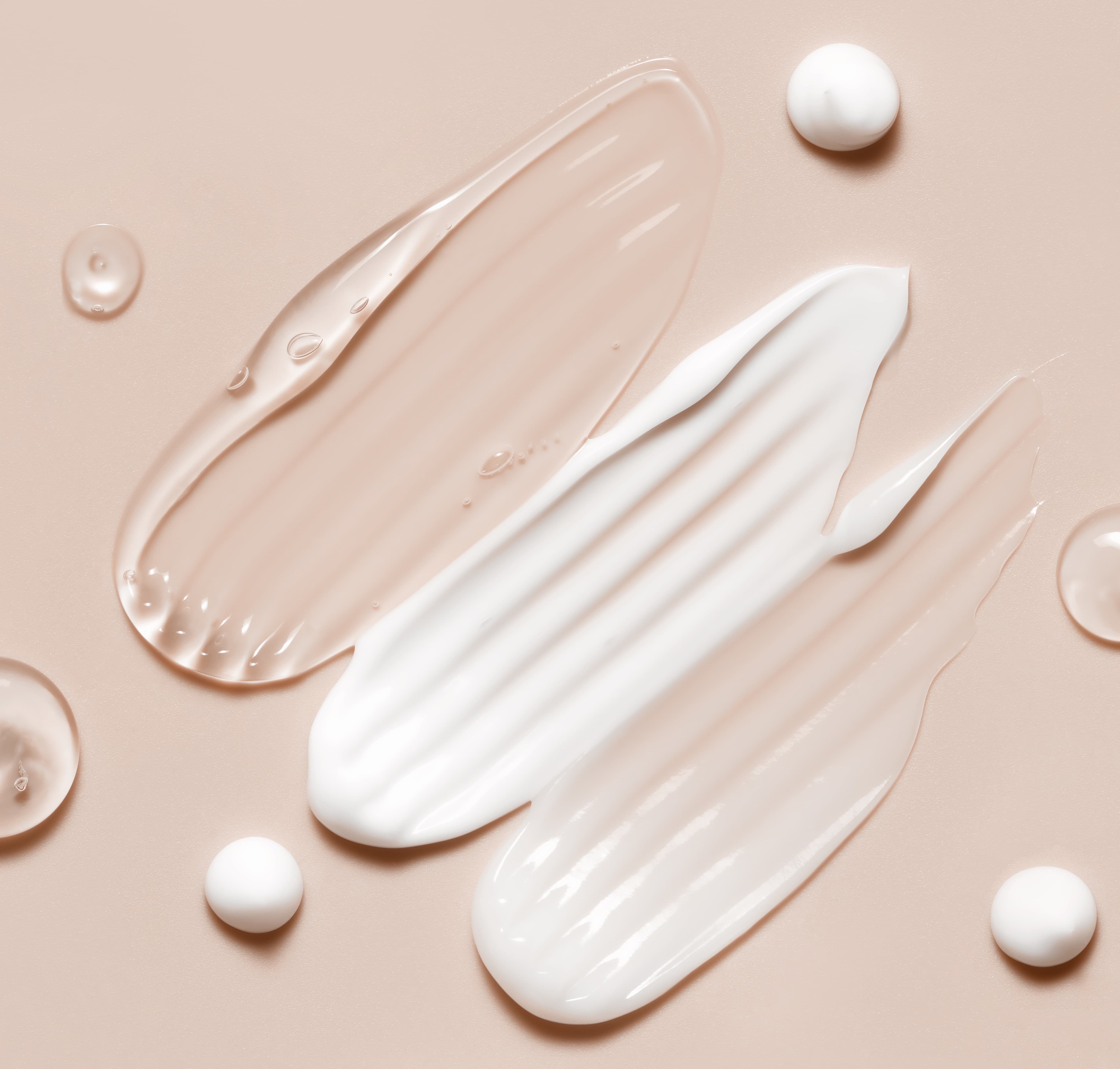 varied skincare gels and creams smeared on background